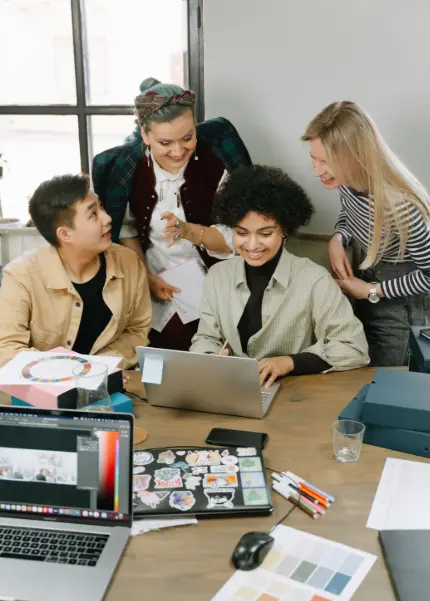 A team collaborating around a laptop