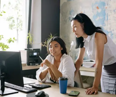 Team members reviewing work at a computer