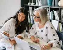 Two team members collaborating over a laptop