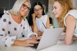 A team discussing work around a laptop